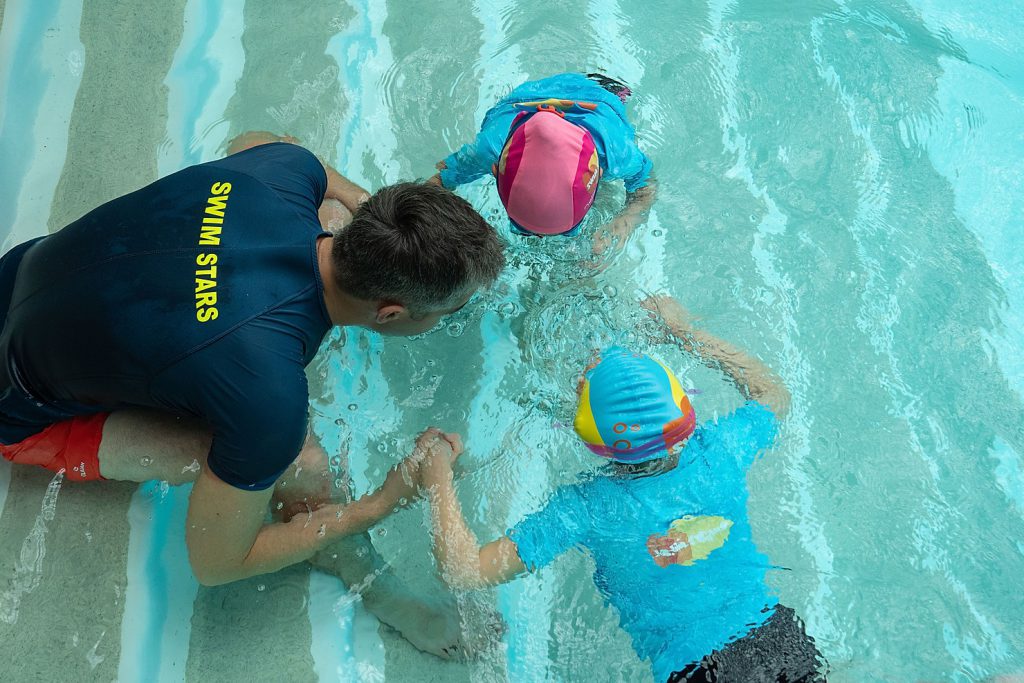 Entrenador y niños en el agua